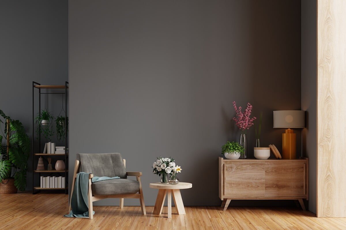 Estancia moderna con un sillón individual gris, acabados de madera, accesorios y separación de muro